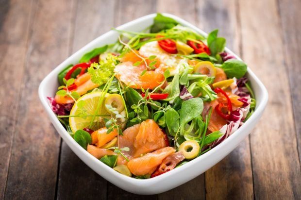 Red fish salad with greens, olives and sharp pepper