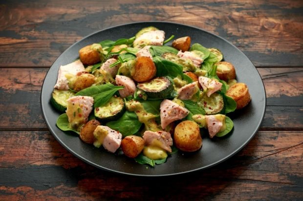 Salad with boiled red fish, fried tsukini and potatoes